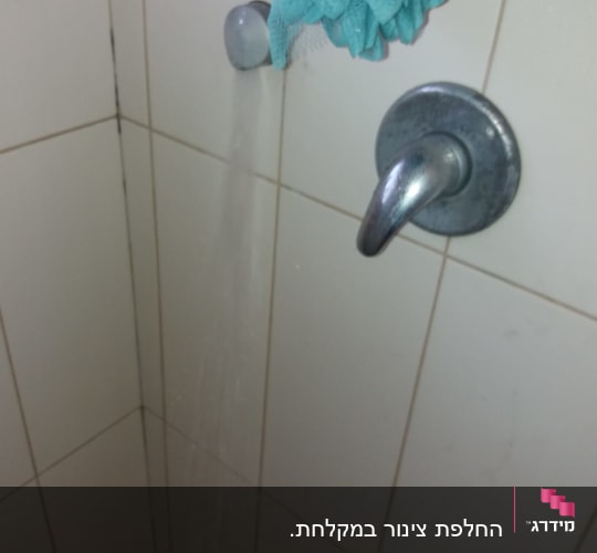 ברז מים זורם במקלחת עם ספוג תלוי